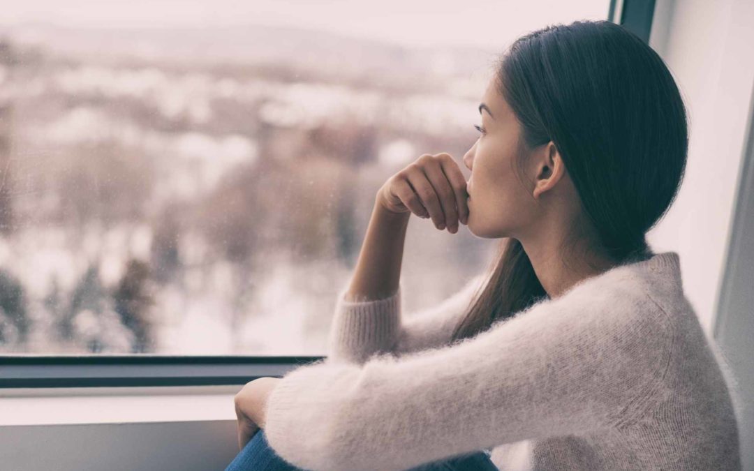 woman somberly looking through train window
