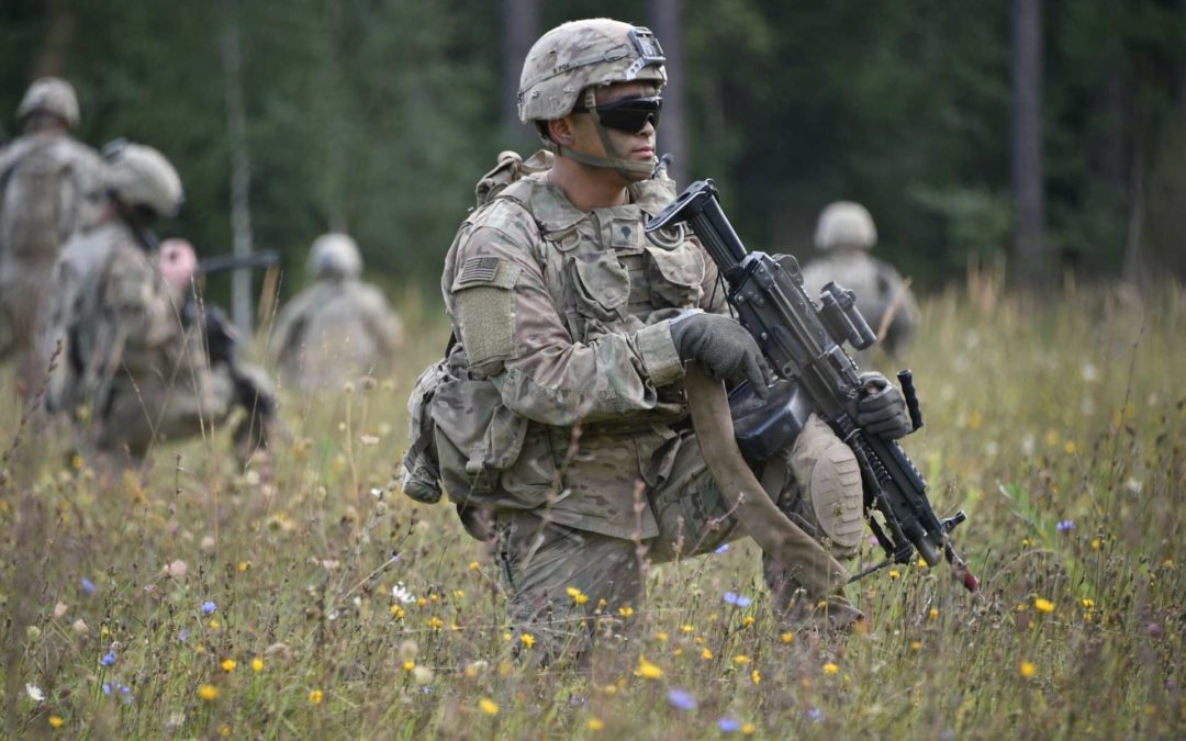 soldiers in a field with firearms