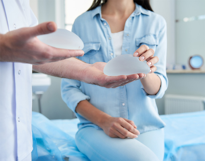 Woman at doctors office looking at textured breast implants with her doctor.