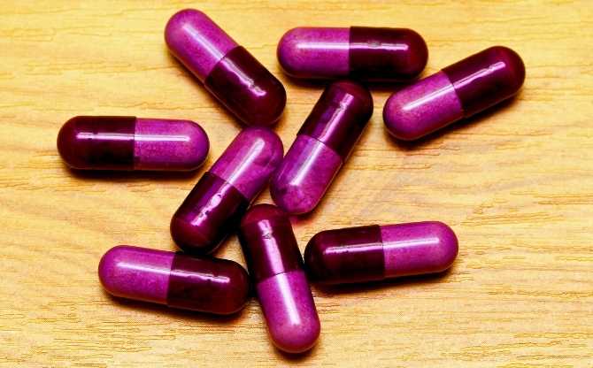 purple pills on a wood table